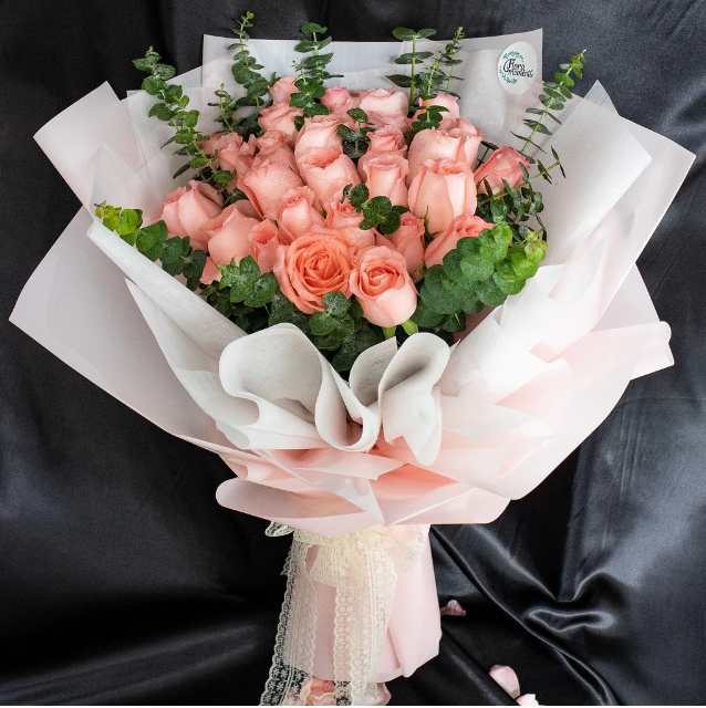 flowerbouquet-pink-roses-eucalyptus-in-pink-wrapper-with-black-backdrop