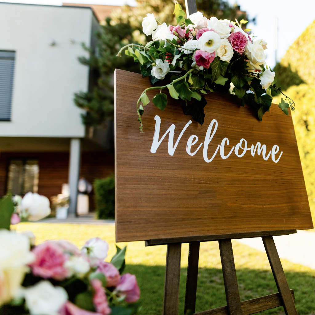 A welcome sign with flowers in front of an office.