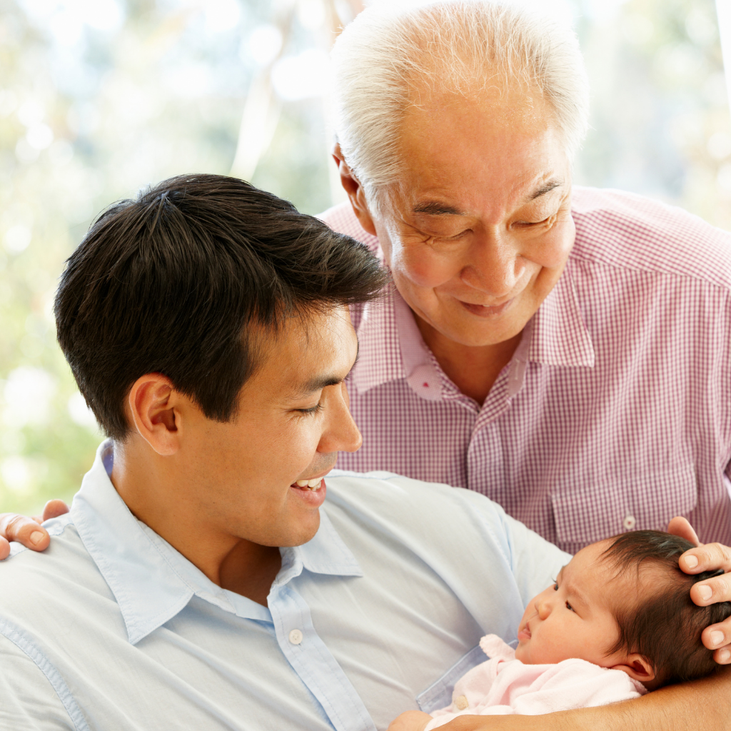 A man gently cradling a baby in his arms, showcasing the bond between a father and child.