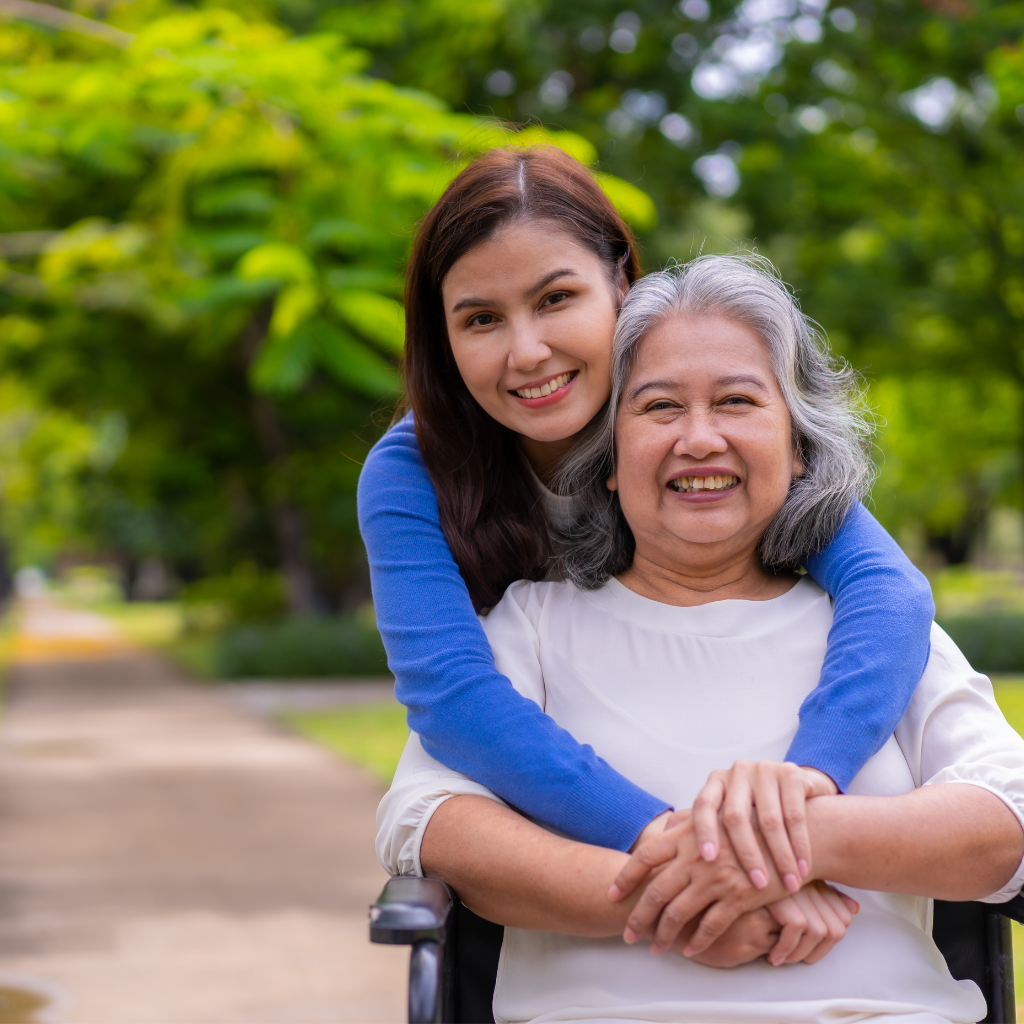 An Asian woman lovingly pushes her mother in a wheelchair, sharing a special bond of care and support.