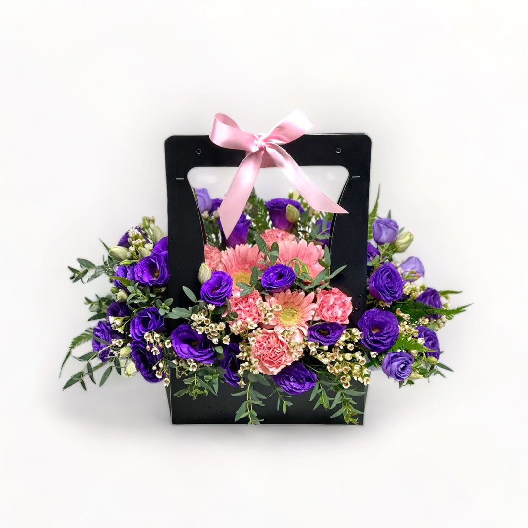 florabasket-pink-gerberas-purple-eustomas-and-pink-carnations-black-basket-ribbon-with-white-background