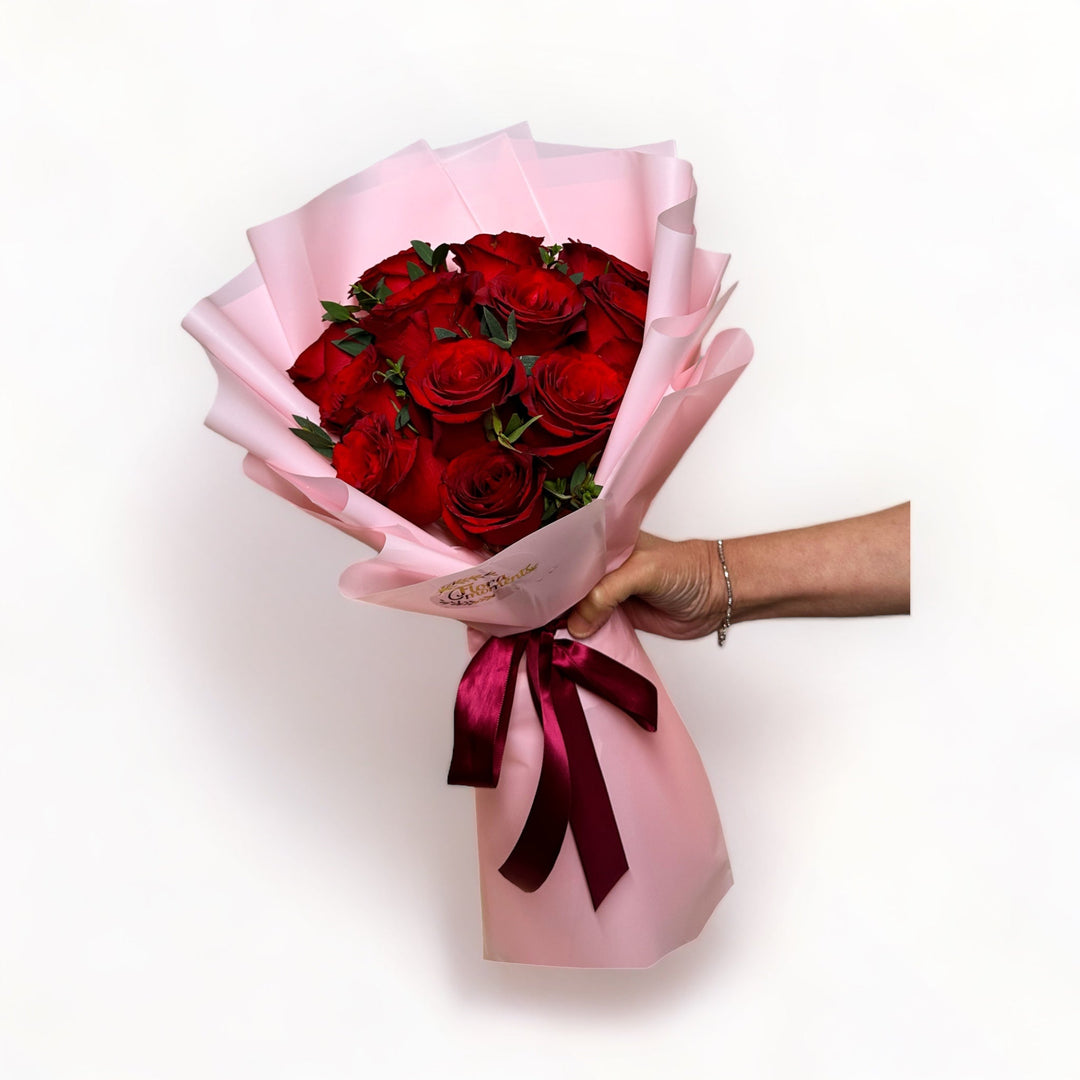 bouquet-of-12-stalks-red-roses-wrapped-in-pink-hand