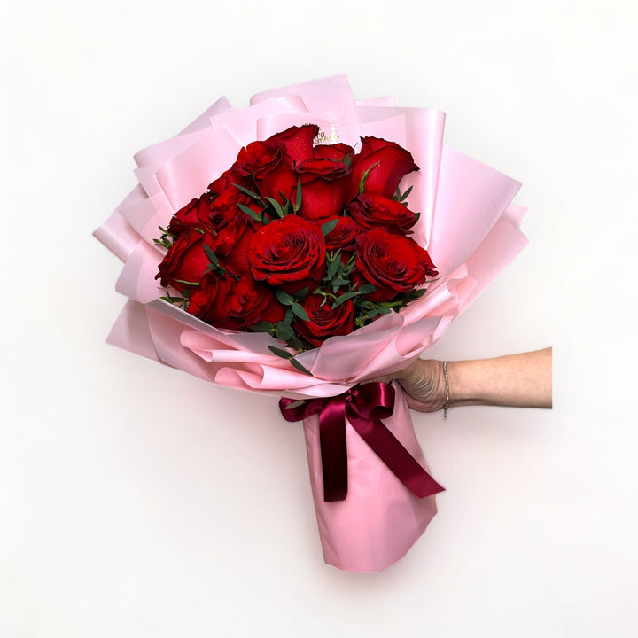 bouquet-of-18-stalks-red-roses-wrapped-in-pink-hand