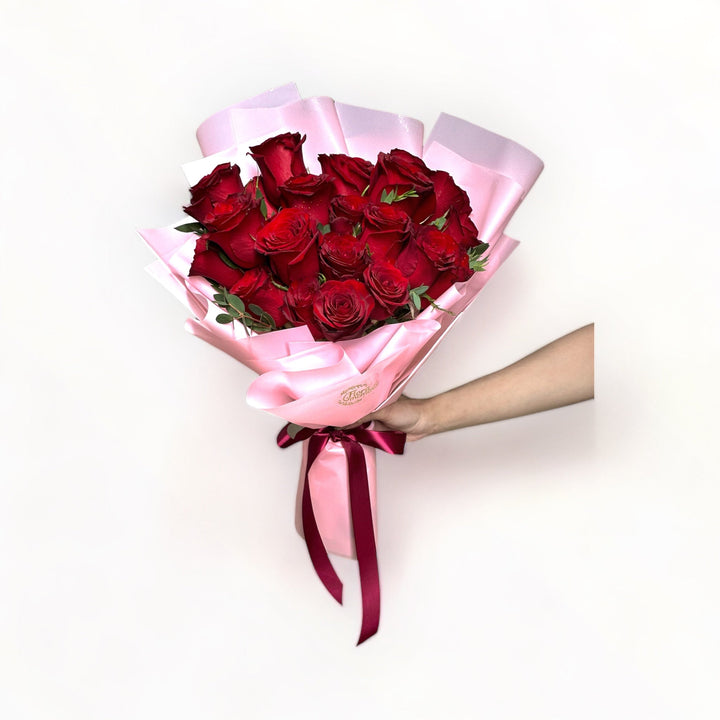 bouquet-of-24-stalks-red-roses-wrapped-in-pink-hand