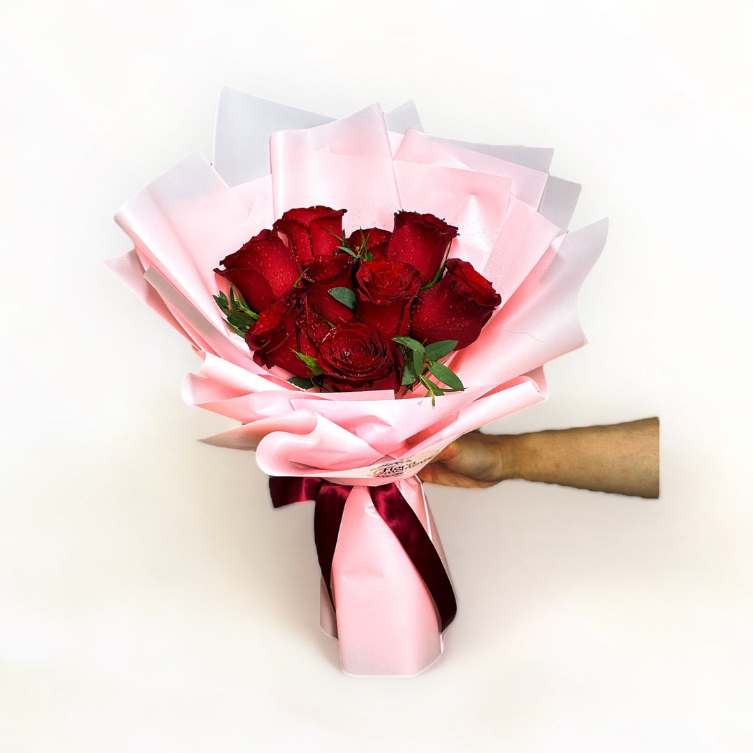 bouquet-of-9-stalks-red-roses-wrapped-in-pink-hand