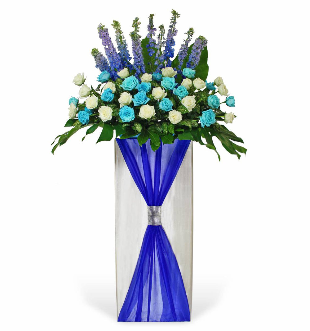 flowerstand-blue-delphinium-with-white-and-blue-super-roses-with-white-background 